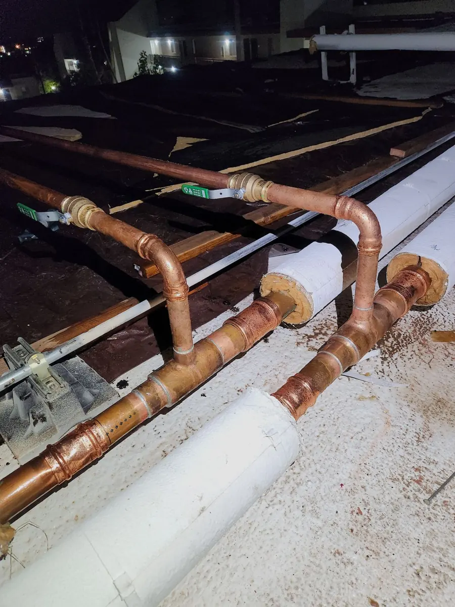 Large copper and steel pipe runs on a commercial wall