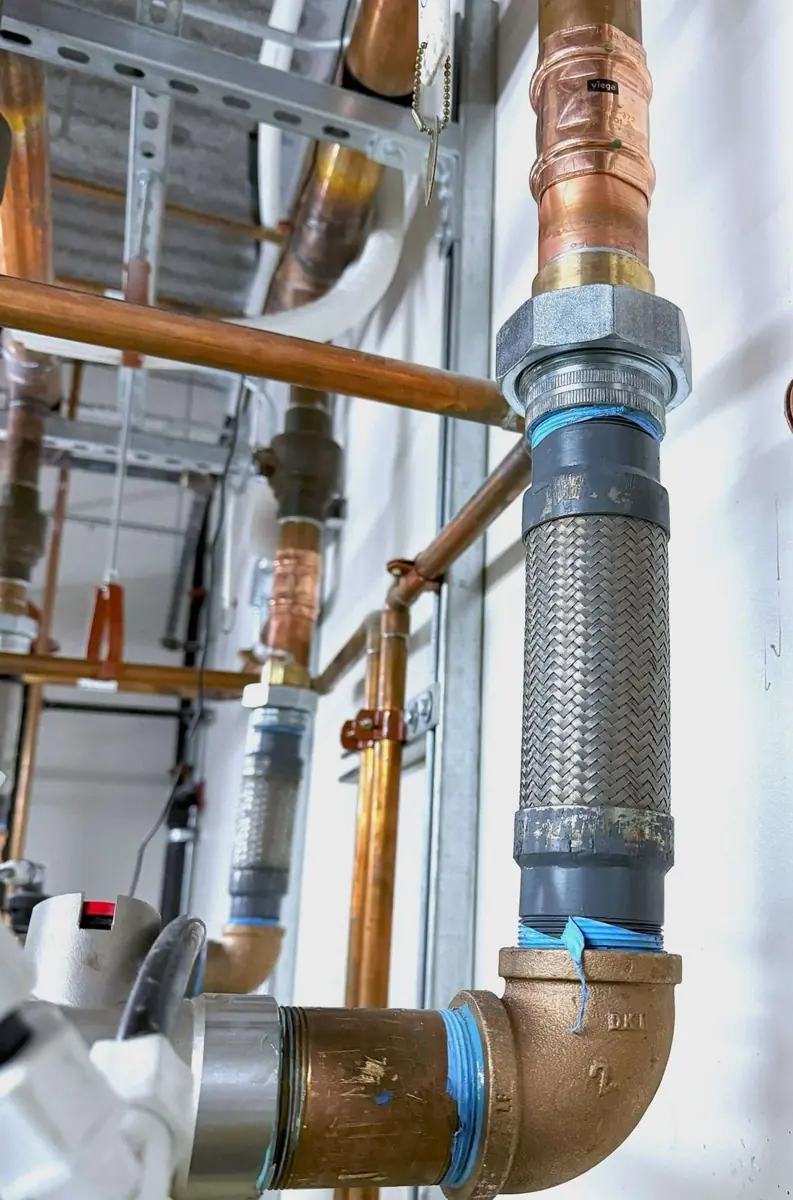Copper elbow joining a large steel line